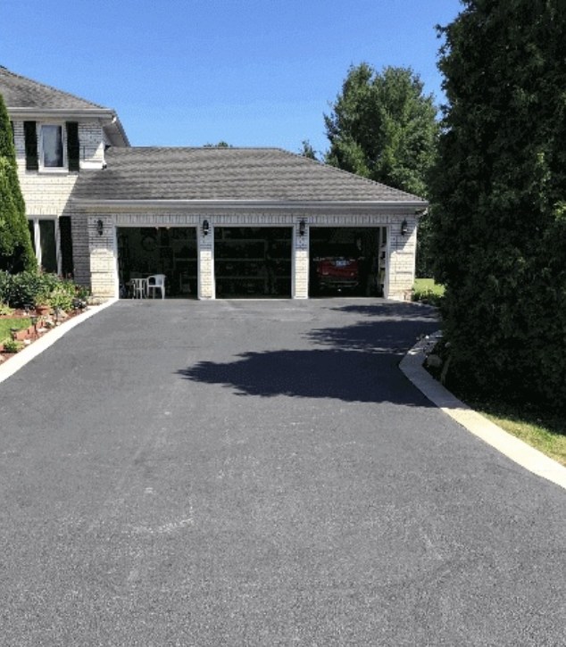 Driveway before sealcoating — faded, weathered grey asphalt