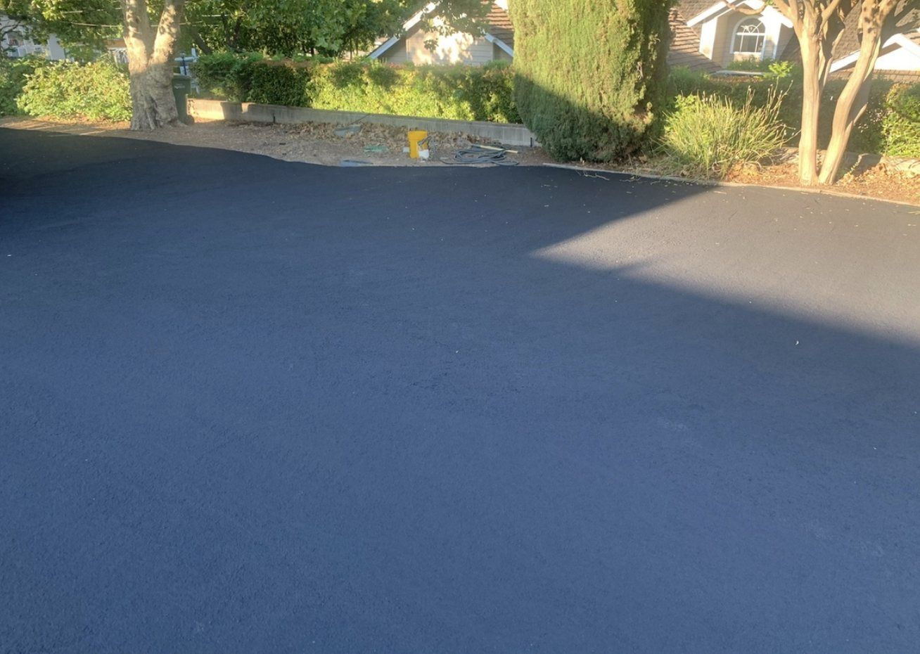 Asphalt after a fresh sealcoat — clean, even black surface